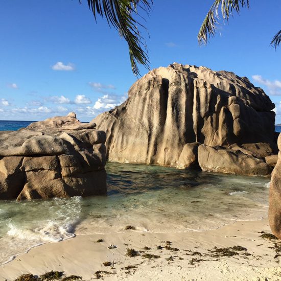 Vackra bergsformationer på stranden i La Digue på Seychellerna